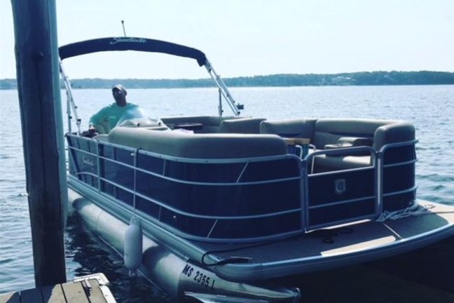 A pontoon boat at a doc